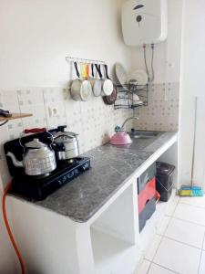eine Küche mit einer Arbeitsplatte mit Töpfen und Pfannen in der Unterkunft Appartement à M'diq in Mʼdik
