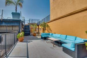 ロサンゼルスにあるDowntown Los Angeles Condo with Shared Rooftop Pool!の建物の横に青いソファ付きのパティオ