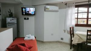 a room with a kitchen with a tv on the wall at Los Tres Lapachos "Orange" in Salta