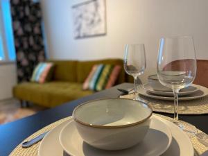 a table with a bowl and two wine glasses on it at Funky City Apartment in Rovaniemi