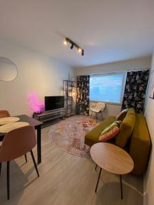 a living room with a green couch and a tv at Funky City Apartment in Rovaniemi