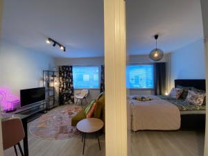 a bedroom with a bed and a living room at Funky City Apartment in Rovaniemi