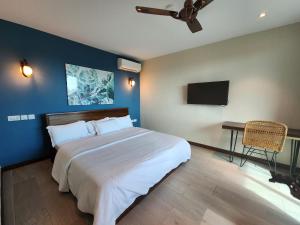 a bedroom with a large bed and a flat screen tv at ALERI'S GARDEN in Big Ada