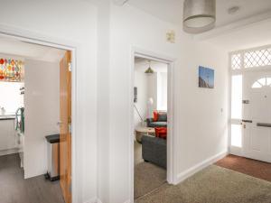 ein Wohnzimmer mit weißen Wänden und ein Wohnzimmer in der Unterkunft The White Cottage in Weymouth