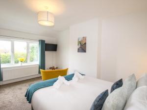 ein Schlafzimmer mit einem weißen Bett und einem Fenster in der Unterkunft The White Cottage in Weymouth