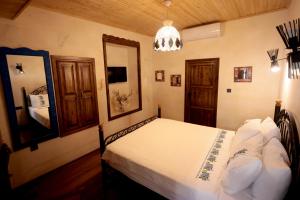 - une chambre avec un lit doté de draps blancs et d'un miroir dans l'établissement ASTARTE HOTEL, à Şanlıurfa