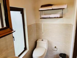 a small bathroom with a toilet and towels at La Arboleda, Refugio in Cogua