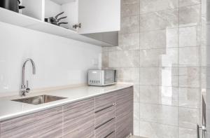 a kitchen with a sink and a microwave at Beautiful 2Bedroom apartment in Singapore! in Singapore