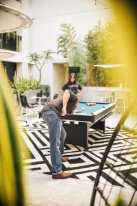 una mujer sentada encima de una mesa de ping pong en The Godfrey Hotel Hollywood en Los Ángeles