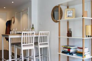 a dining room with a table and two white stools at Chez Pascal - Nieuport in Nieuwpoort +7 photos
