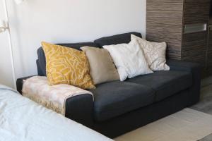 a blue couch with pillows on it in a room at Chez Pascal - Nieuport in Nieuwpoort