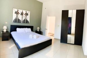 1 dormitorio con 1 cama y 2 toallas blancas en Villa Sueño Caribeño N 91 en Boca Chica