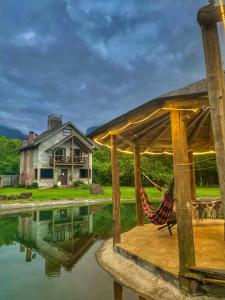 a hammock on a porch next to a house at Pousada & Camping Nativos dos Canyons in Praia Grande