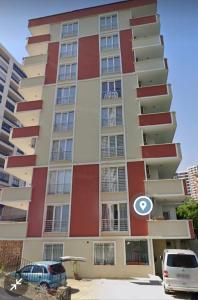 een hoog appartementencomplex met een rode en witte gevel bij اجنحة الراحة للشقق الفندقية Comfort Suites in Komera