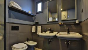 bagno con 3 lavandini e servizi igienici di FORVM bijoux ROOMS a Trieste