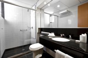 a bathroom with a toilet and a sink and a shower at H2 Platinum Lourdes in Belo Horizonte