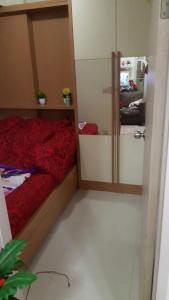 a bedroom with a red bed and a mirror at Rumah Marom in Bekasi