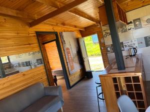 Habitación grande de madera con cocina y sala de estar. en Cabañas Luz de Luna, Playa Curanipe, en Curanipe