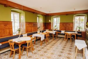 uma sala de jantar com mesas e cadeiras e paredes verdes em Boutiquehotel Lindenhof em Oberdrauburg