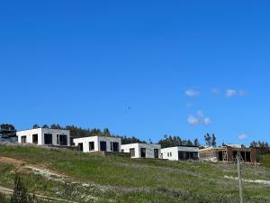 a row of white houses on top of a hill at Cabañas Luz de Luna, Playa Curanipe in Curanipe