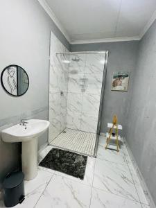 a white bathroom with a shower and a sink at The Bliss Boutique in Louis Trichardt