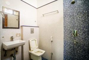 a bathroom with a toilet and a sink and a shower at HOTEL ATHITI INN JAIPUR in Jaipur
