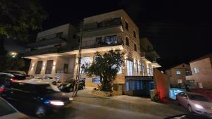 a building with cars parked in front of it at night at תבל PRIVATE HOTEL in Jerusalem