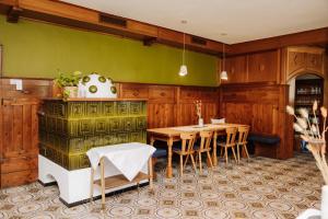 une salle à manger avec une table et un mur vert dans l'établissement Boutiquehotel Lindenhof, à Oberdrauburg