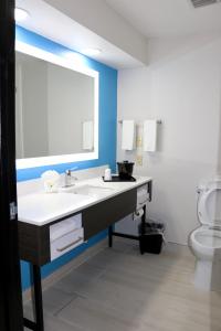 La salle de bains est pourvue d'un lavabo, d'un miroir et de toilettes. dans l'établissement Quality Inn & Suites, à Buda