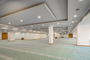 a large room with white walls and white columns at Elaf Bakkah Hotel in Mecca