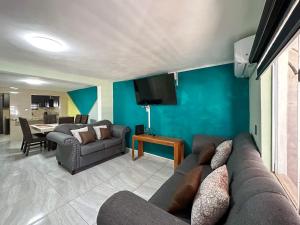 ein Wohnzimmer mit einem Sofa und einem TV in der Unterkunft Town Gem Getaway 3 Bed House with Pool in Puerto Peñasco