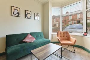 a living room with a green couch and a table at Home from Home 4 Bed - Ideal for Workers & Great for Groups, FREE Parking, Spacious, Pet Friendly Netflix in Kimberworth