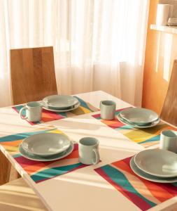 un tavolo con piatti e tazze su una tovaglia colorata di Apartamento Campestre a Fusagasugá