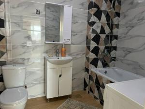 y baño con aseo, lavabo y bañera. en Уютная квартира комфорт класса - 41, en Astana