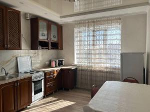cocina con fregadero y fogones horno superior en Уютная квартира комфорт класса - 41, en Astana