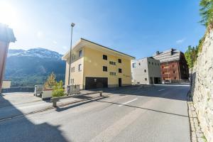 a building on a street with a bench in front of it at Chesa Bellavista - St. Moritz in St. Moritz