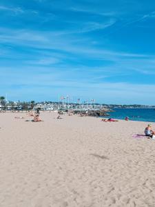 a beach with people laying on the sand and the ocean at Appartement 2 chambres parking Port Fréjus Base Nature in Fréjus