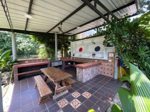 an outdoor kitchen with benches and a table at Catleya Cabaña Campestre in Villavicencio