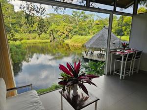 a room with a large window looking out onto a lake at Lagoon Village B&B y SPA in Tarapoto