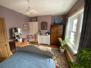 a bedroom with a blue bed and a window at Cardiff - Home from Home in Cardiff