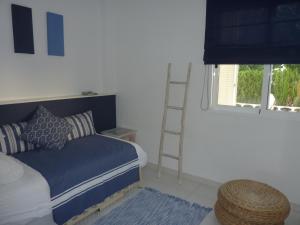 a bedroom with a bed and a ladder next to a window at CALA BLANCA in Denia