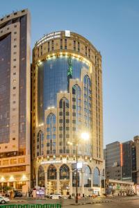 a large building with lights on the side of it at Elaf Al Mashaer Hotel Makkah in Makkah