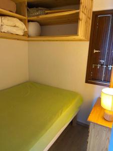 a green bed in a room with a window at T2, 5/6 pl, superbe vue, exp sud, douche italienne in LʼHuez