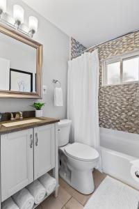 y baño con aseo, lavabo y espejo. en Stunning 4 BD Home near Tilles Park - JZ Vacation Rentals, en Richmond Heights