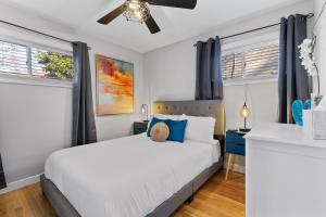 1 dormitorio con 1 cama blanca y 2 ventanas en Stunning 4 BD Home near Tilles Park - JZ Vacation Rentals, en Richmond Heights