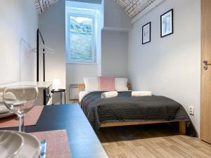 Dormitorio pequeño con cama y mesa en ELSO apartments, en Praga