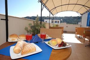 サン・ヴィート・ロ・カーポにあるB&B Amoreoのパン2皿と果物が入ったテーブル