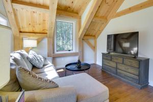 a living room with a couch and a flat screen tv at Cozy Camden Cottage with Fire Pit and Trail Access in Camden