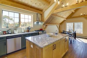 una cocina con una isla grande en una habitación con techos de madera en Cozy Camden Cottage with Fire Pit and Trail Access en Camden