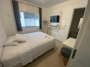 a hospital room with a white bed and a desk at Hotel Rota Dos Tropeiros in Castro